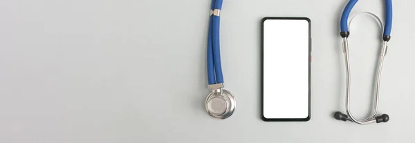 Tıbbi uygulamalar için cep telefonu modeli. Akıllı telefon beyaz ekran modeli ve sağlık uygulaması için steteskop. Metin için kopyalama alanı olan pankart