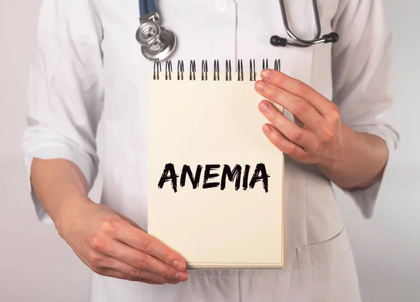 Anemia word on notebook paper in doctor hand