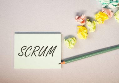 Ofis masasındaki kâğıt üzerinde Scrum kelimesi, üst görünüm. Yönetimdeki yöntemler kavramı