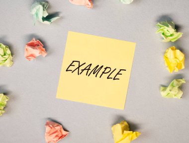 Gri arkaplandaki sarı notla ilgili örnek sözcük, buruşuk kağıtlar, üst görünüm