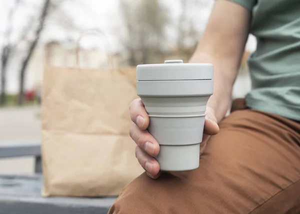 Copo dobrável para tomar café ou chá. Mão masculina com caneca de silício sustentável. Estilo de vida ecológico do homem na cidade — Fotografia de Stock