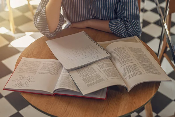 Veel boeken op houten bureau in modern café of bibliotheek. Concept van onderzoek en het zoeken naar antwoorden in leerboeken — Stockfoto