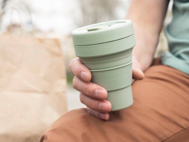 Hazır kahve için katlanabilir silikon eko bardak. Sürdürülebilir kupası olan bir erkek.