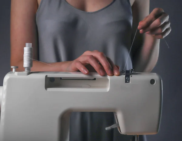 Mains de couture mettant le fil sur la machine à coudre, processus de travail — Photo
