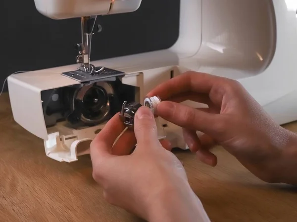 Seamstress mãos inserção de rosca no carretel ou bobina da máquina de costura, iniciando o trabalho, fixação e reparação — Fotografia de Stock