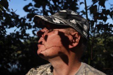 Dışarıdaki sakin adamın portresi, doğaya dalmış, rahatlıyor ve nefes alıyor, yüzünde gölgeler var.