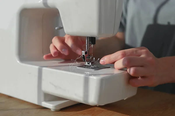 Mãos de agulha inserindo linha através do furo da agulha na máquina de costura, close-up, começando o trabalho — Fotografia de Stock