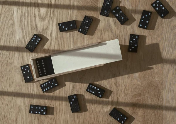 Domino hra, otevřené dřevěné krabice s kousky roztroušené po dřevěném stole — Stock fotografie