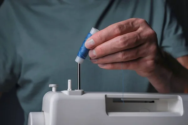 Руки накладывают нитку на швейную машинку крупным планом — стоковое фото