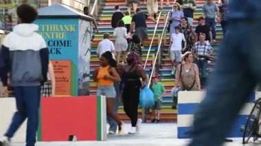 Londra, İngiltere - 1 Temmuz 2021: Yüzü maskeli bir grup insan Londra Southbank Center 'da renkli merdivenlerden inip çıkıyorlar.