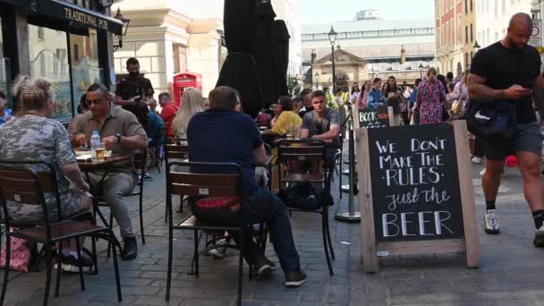 ロンドン イギリス 2021年7月1日 コベントガーデンのパブで屋外で食事をしている人たちは ビールだけでルールを作っていない という看板の横に座っていました — ストック動画