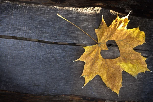 Jesień liść żółty z z drewnianym tle heartover — Zdjęcie stockowe