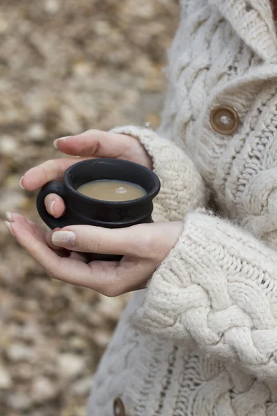 Cup of mug of hot drink in female hands on warm sweater — Stock Photo, Image