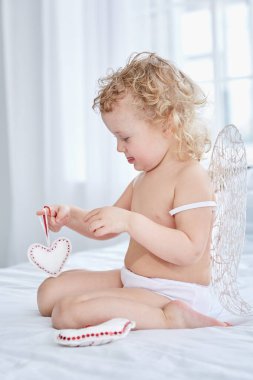 Aşk tanrısı dışarıda dille konsantre olmuş kalplerle oynuyor.