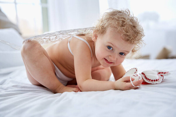 cupid cherubim playing hiding on a bed