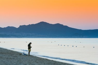 Kumsalda güneş doğarken Balık tutma
