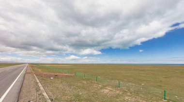 Çin 'in Qinghai eyaletinde dağlar ve otlaklar karayoluyla uzanır.