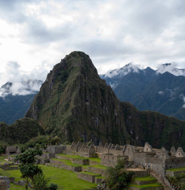 Machu Picchu 'nun Peru' daki panoramik manzarası harabe. Arkasında yeşil bitki örtüsüyle dolu büyük ve güzel dağları takdir edebiliriz. Arkeolojik alan, Unesco Dünya Mirası