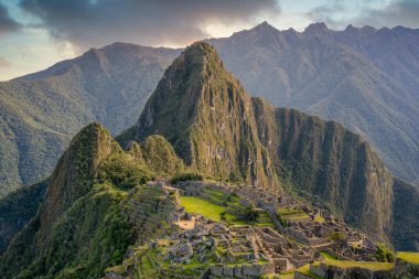 Machu Picchu 'nun Peru' daki panoramik manzarası harabe. Arkasında yeşil bitki örtüsüyle dolu büyük ve güzel dağları takdir edebiliriz. Arkeolojik alan, Unesco Dünya Mirası
