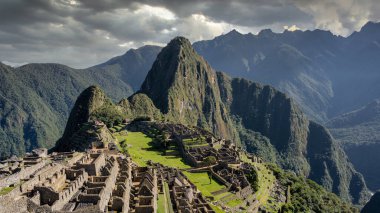 Machu Picchu 'nun Peru' daki panoramik manzarası harabe. Arkasında yeşil bitki örtüsüyle dolu büyük ve güzel dağları takdir edebiliriz. Arkeolojik alan, Unesco Dünya Mirası