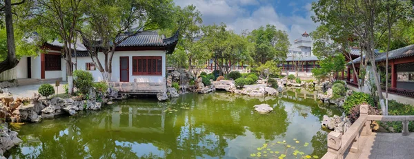 Chinese classical courtyard with small bridge and water.