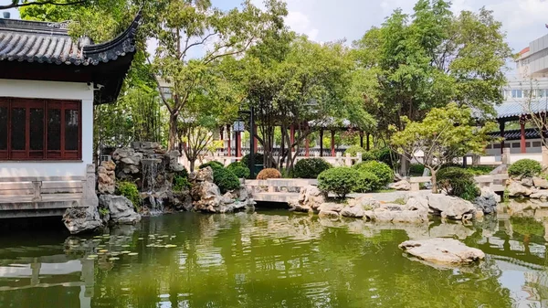Chinese classical courtyard with small bridge and water.