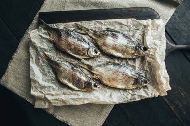 Lezzetli taze, kurutulmuş vahşi deniz nehri kırmızı ve beyaz balıklar ahşap bir kahverengi tahta üzerinde kağıt üzerinde keten kumaş, bez, börgü, koç, uskumru, ringa balığı, baharatlar ve ahşap bir masa üzerinde güzel bir renk kombinasyonu.