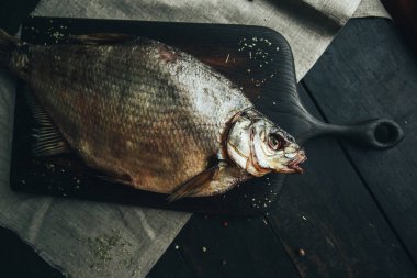 Lezzetli taze, kurutulmuş vahşi deniz nehri kırmızı ve beyaz balıklar ahşap bir kahverengi tahta üzerinde kağıt üzerinde keten kumaş, bez, börgü, koç, uskumru, ringa balığı, baharatlar ve ahşap bir masa üzerinde güzel bir renk kombinasyonu.