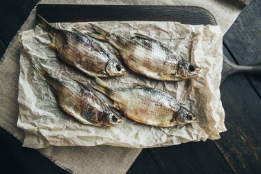 Lezzetli taze, kurutulmuş vahşi deniz nehri kırmızı ve beyaz balıklar ahşap bir kahverengi tahta üzerinde kağıt üzerinde keten kumaş, bez, börgü, koç, uskumru, ringa balığı, baharatlar ve ahşap bir masa üzerinde güzel bir renk kombinasyonu.