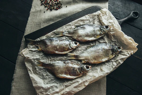 Lezzetli taze, kurutulmuş vahşi deniz nehri kırmızı ve beyaz balıklar ahşap bir kahverengi tahta üzerinde kağıt üzerinde keten kumaş, bez, börgü, koç, uskumru, ringa balığı, baharatlar ve ahşap bir masa üzerinde güzel bir renk kombinasyonu.