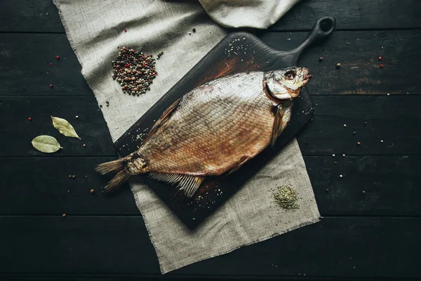 Lezzetli taze, kurutulmuş vahşi deniz nehri kırmızı ve beyaz balıklar ahşap bir kahverengi tahta üzerinde kağıt üzerinde keten kumaş, bez, börgü, koç, uskumru, ringa balığı, baharatlar ve ahşap bir masa üzerinde güzel bir renk kombinasyonu.