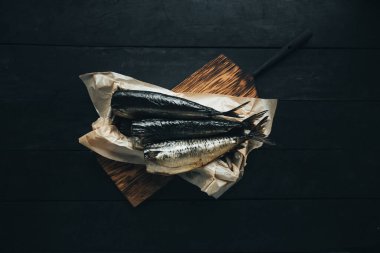 Lezzetli taze, kurutulmuş vahşi deniz nehri kırmızı ve beyaz balıklar ahşap bir kahverengi tahta üzerinde kağıt üzerinde keten kumaş, bez, börgü, koç, uskumru, ringa balığı, baharatlar ve ahşap bir masa üzerinde güzel bir renk kombinasyonu.