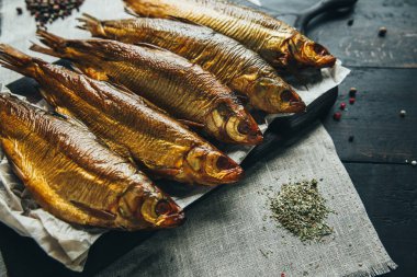 Lezzetli taze, kurutulmuş vahşi deniz nehri kırmızı ve beyaz balıklar ahşap bir kahverengi tahta üzerinde kağıt üzerinde keten kumaş, bez, börgü, koç, uskumru, ringa balığı, baharatlar ve ahşap bir masa üzerinde güzel bir renk kombinasyonu.
