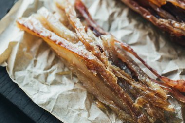 Lezzetli kırmızı ve beyaz vahşi deniz nehri kurumuş balık dilimleri parşömen kağıdının üzerinde parşömen kağıdında kesilmiş güzel bir renk kombinasyonu.