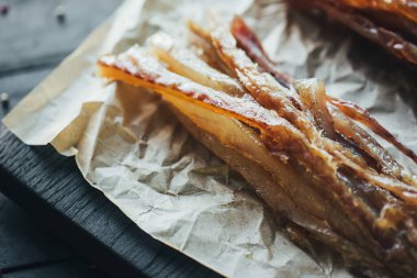 Lezzetli kırmızı ve beyaz vahşi deniz nehri kurumuş balıklar parşömen kağıdındaki tahta kesme tahtasının parçalarına ayrılmış güzel bir renk kombinasyonu.
