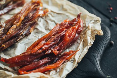 Lezzetli kırmızı ve beyaz vahşi deniz nehri kurumuş balıklar parşömen kağıdındaki tahta kesme tahtasının parçalarına ayrılmış güzel bir renk kombinasyonu.