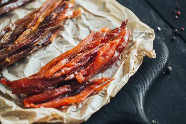 Lezzetli kırmızı ve beyaz vahşi deniz nehri kurumuş balıklar parşömen kağıdındaki tahta kesme tahtasının parçalarına ayrılmış güzel bir renk kombinasyonu.