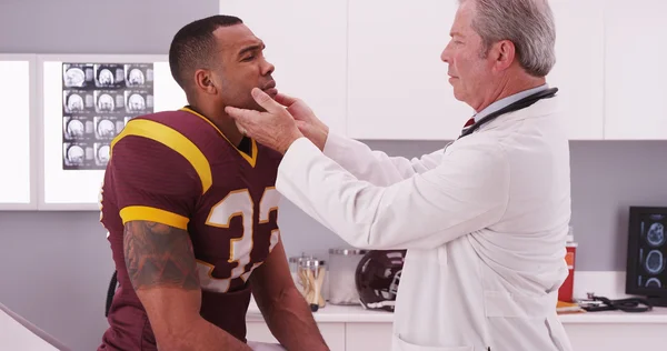 College-Football-Athlet lässt Arzt Hals-Nasen-Ohren-Arzt untersuchen — Stockfoto