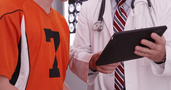 Porträt eines Arztes, der mit Kolle auf einen Tablet-Computer blickt — Stockfoto