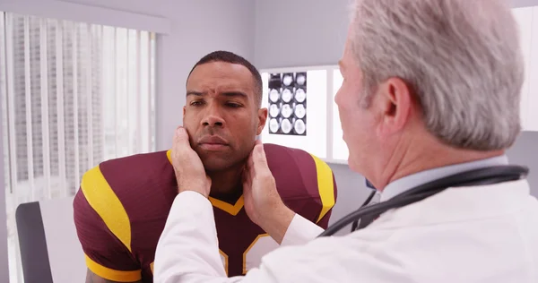 Jugador de fútbol americano universitario que tiene médico senior revisar su conmoción cerebral —  Fotos de Stock