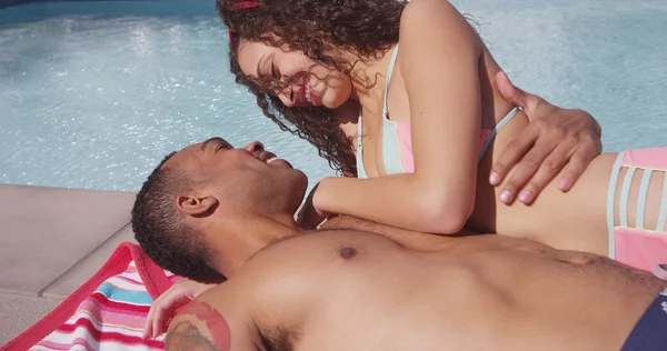4k Hombre negro y mujer hispana besándose junto a la piscina enamorada —  Fotos de Stock