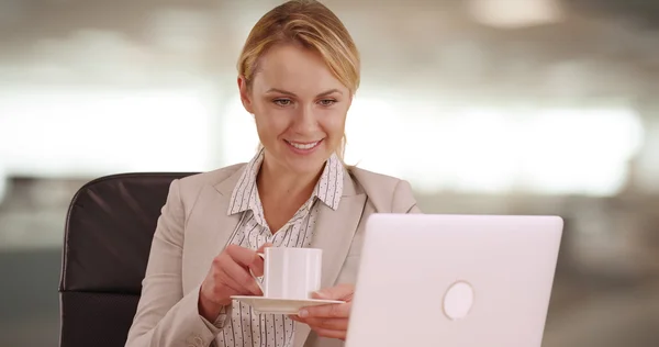 Femme d'affaires heureuse buvant du café au travail — Photo