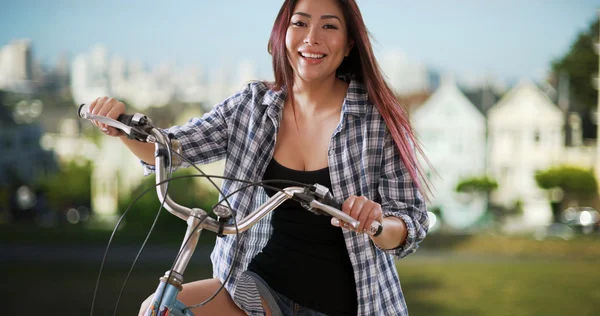 Japanerin lächelt mit ihrem Fahrrad im Park — Stockfoto