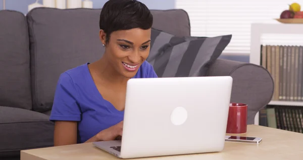 Gelukkig Afrikaanse vrouw gelukkig met behulp van laptopcomputer — Stockfoto