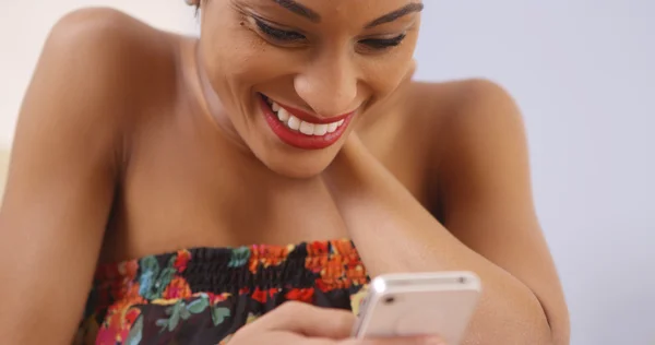 Femme africaine utilisant joyeusement smartphone — Photo