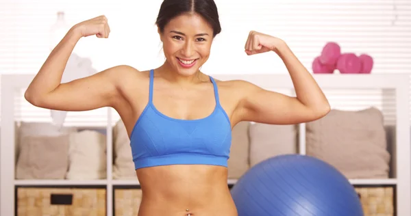 Mujer japonesa sonriendo y flexionando los músculos — Foto de Stock