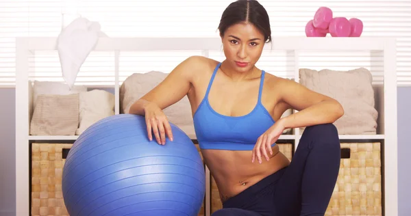 Strong Japanese woman resting on exercise ball — Stock Photo, Image