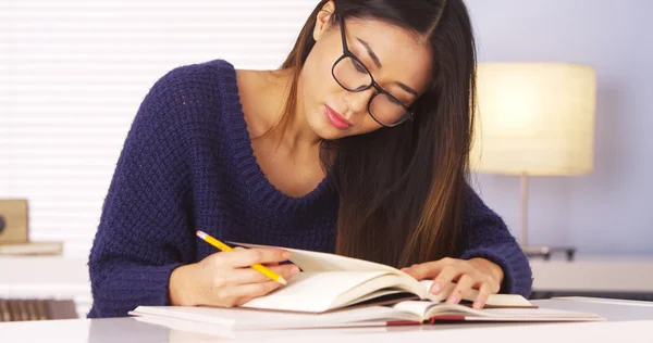 Mujer japonesa leyendo libros y tomando notas Imágenes de stock libres de derechos