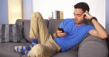 Adam kanepede Smartphone kullanarak