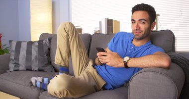 Attractive Mexican man lying on couch clipart